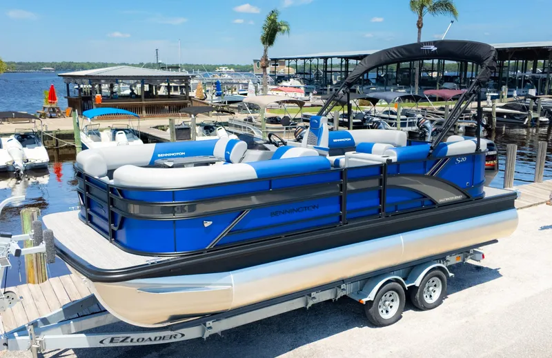 Slide: The Image of 2024 Bennington 20 SSR pontoon boat on trailer at marina dock. - 2