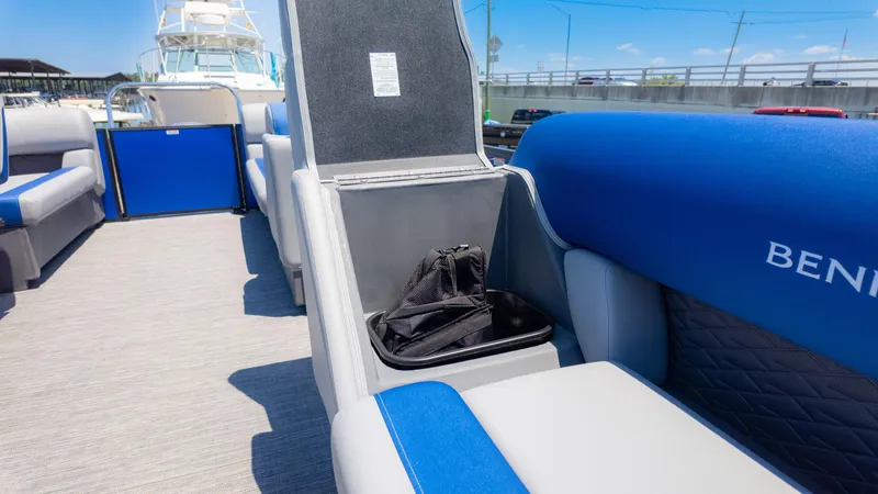 Slide: The Image of 2024 Bennington 20 SSR boat interior with open storage compartment and blue seating. - 24
