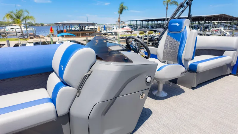 Slide: The Image of 2024 Bennington 20 SSR pontoon boat interior with blue and gray seating, dockside view. - 25