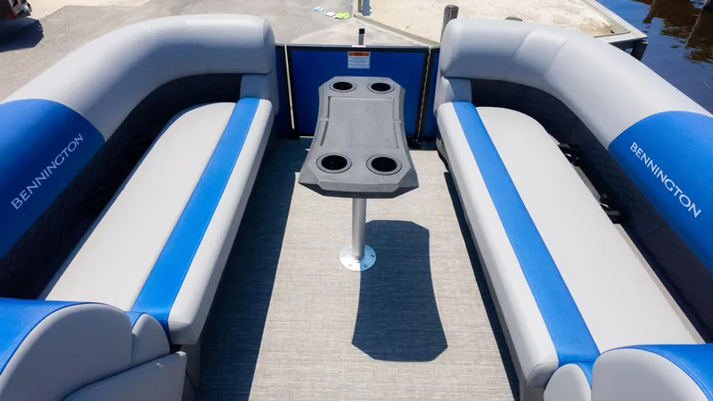 Slide: The Image of 2024 Bennington 20 SSR pontoon boat interior with blue and gray seating and central table. - 9