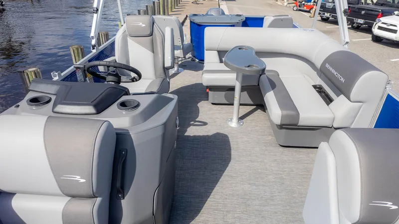Slide: The Image of 2025 Bennington 20 SVS Stern Fish pontoon boat interior with gray seating and steering console. - 11