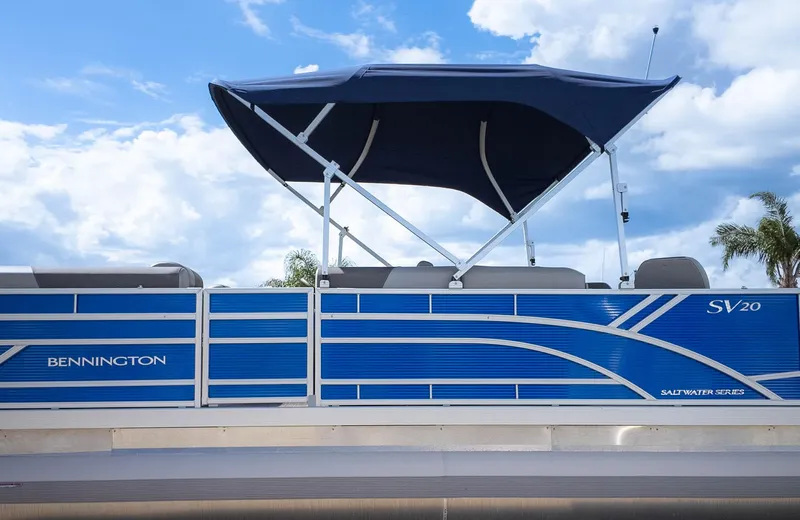 Slide: The Image of 2025 Bennington 20 SVS Stern Fish boat with blue canopy under a cloudy sky. - 4