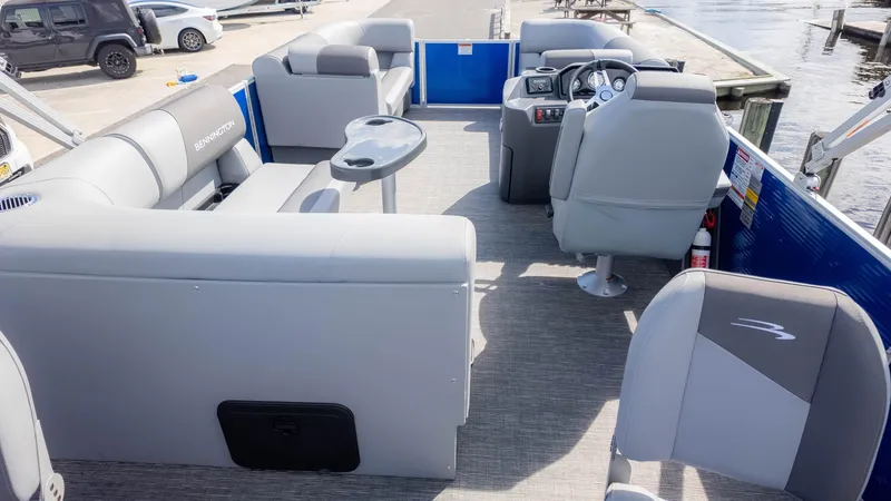 Slide: The Image of 2025 Bennington 20 SVS Stern Fish pontoon boat interior with gray seating and steering console. - 9