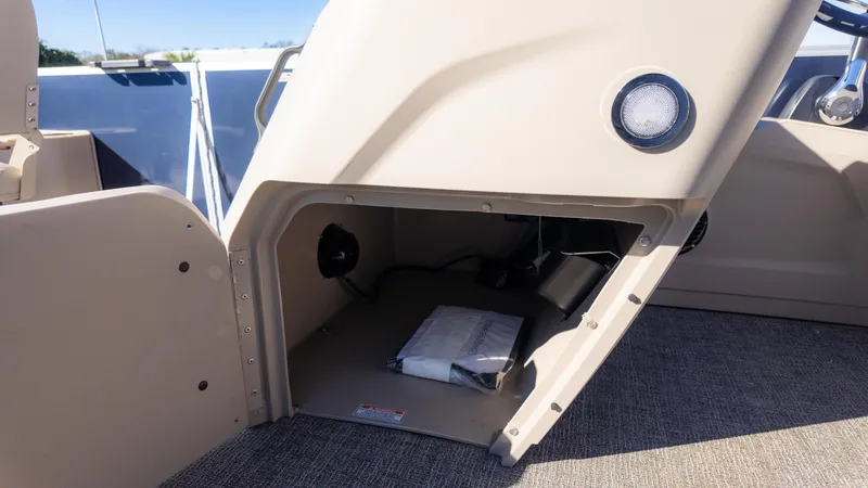 Slide: The Image of Storage compartment in 2025 Bennington 21 SF boat, featuring interior light and carpeted flooring. - 23