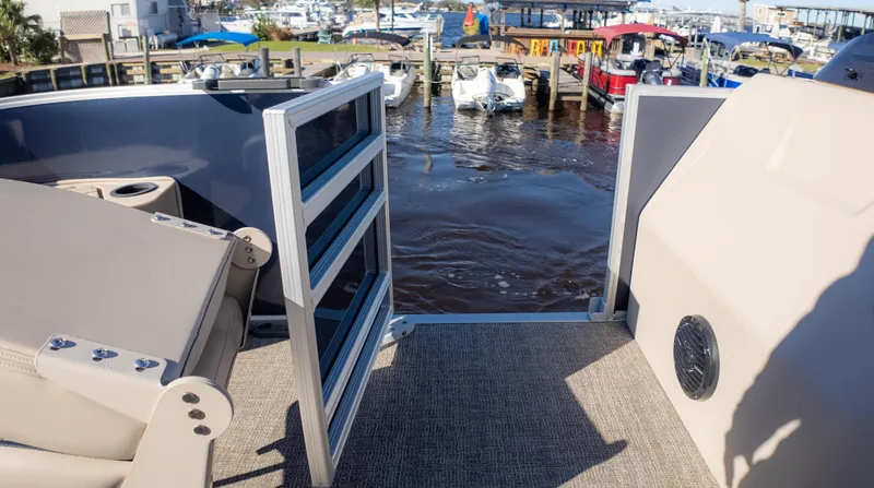 Slide: The Image of 2025 Bennington 21 SF boat interior with open gate, overlooking marina. - 27