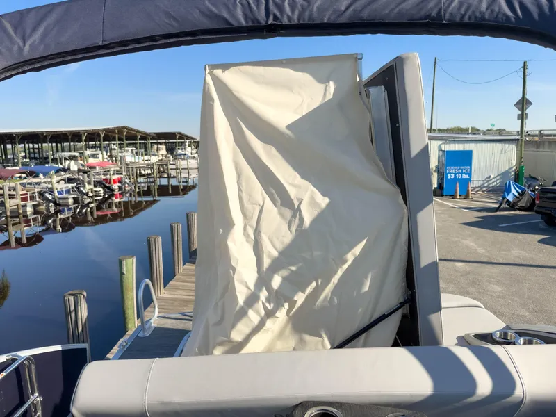 Slide: The Image of 2024 Bennington 22 LSB boat at marina with covered seating area. - 18