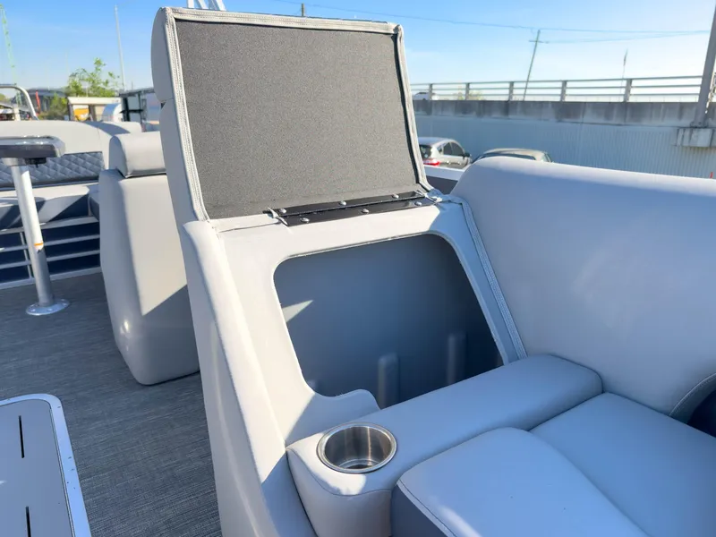 Slide: The Image of 2024 Bennington 22 LSB boat interior with open storage compartment and cup holder. - 26