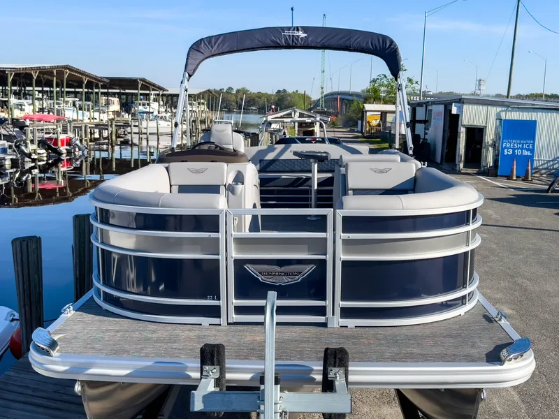 Slide: The Image of 2024 Bennington 22 LSB pontoon boat docked at marina, featuring sleek design and comfortable seating. - 3