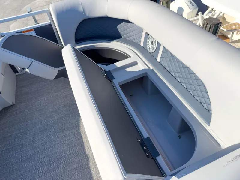 Slide: The Image of 2024 Bennington 22 LSB boat interior with open storage compartment and cushioned seating. - 30