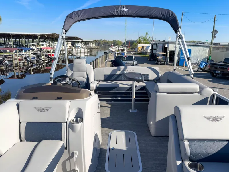 Slide: The Image of 2024 Bennington 22 LSB pontoon boat with spacious seating and sleek design at a marina. - 33