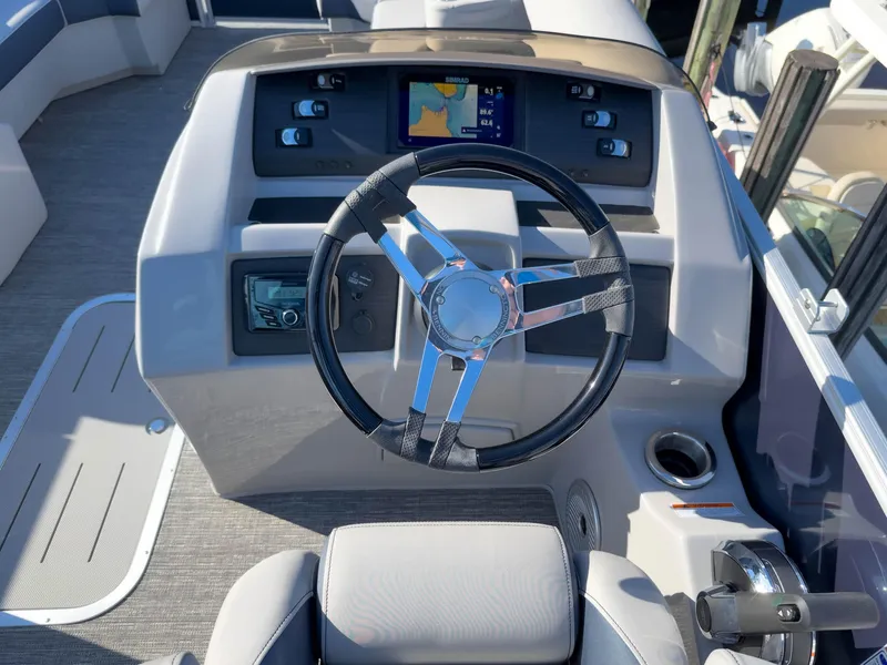 Slide: The Image of 2024 Bennington 22 LSB boat dashboard with steering wheel and navigation display. - 37