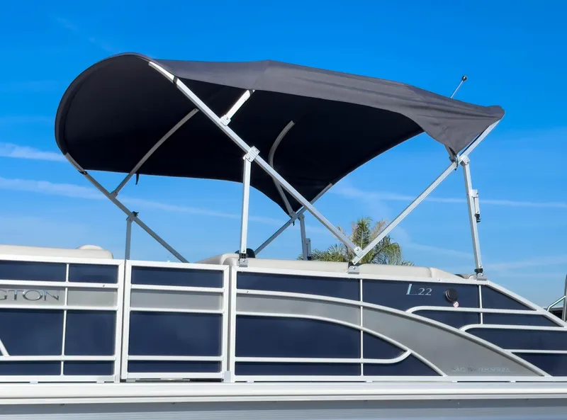 Slide: The Image of 2024 Bennington 22 LSB pontoon boat with canopy against clear blue sky. - 42