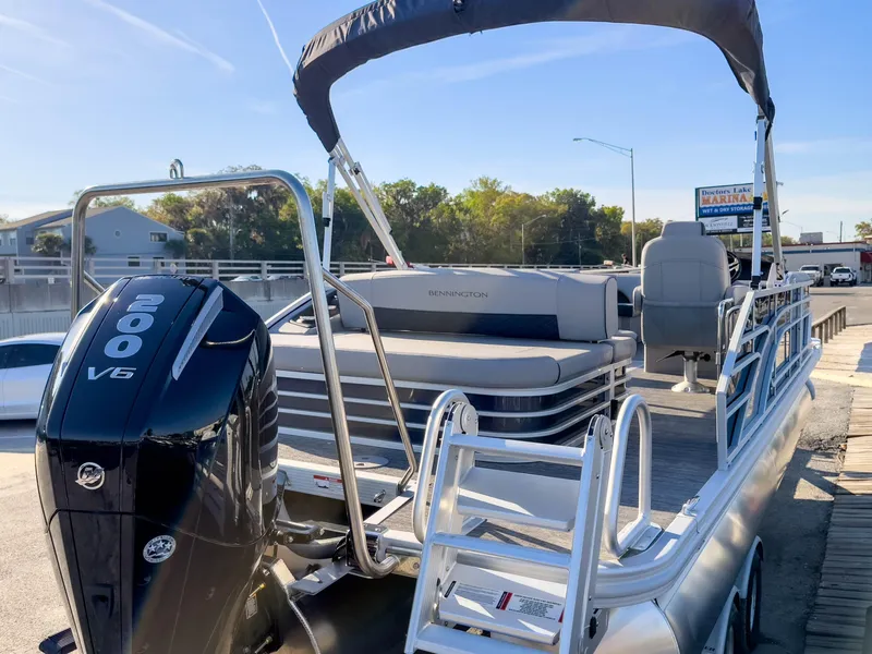 Slide: The Image of 2024 Bennington 22 LSB pontoon boat with 200 V6 engine, docked at marina. - 6