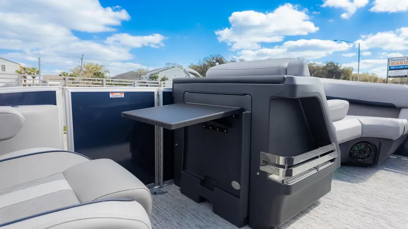 Slide: The Image of 2025 Bennington 22 MFB pontoon boat interior with seating and table under a blue sky. - 14