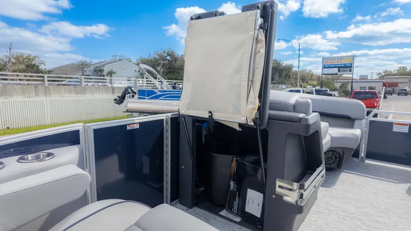 Slide: The Image of 2025 Bennington 22 MFB pontoon boat interior with seating and storage, under a clear blue sky. - 15