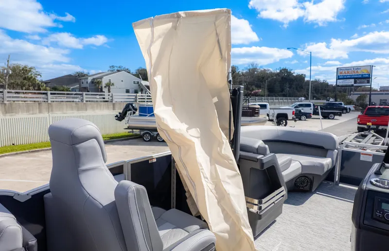 Slide: The Image of 2025 Bennington 22 MFB pontoon boat with seating and canopy, parked outdoors under blue sky. - 16