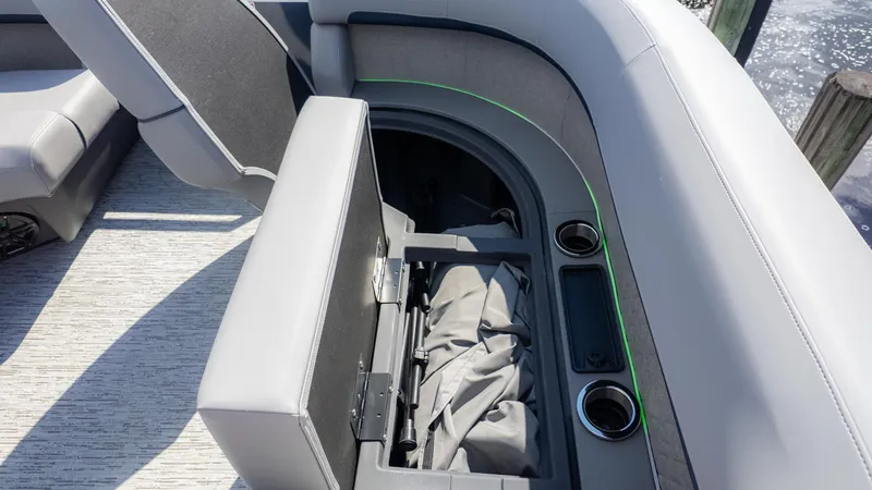 Slide: The Image of 2025 Bennington 22 MFB boat interior with open storage compartment and cup holders. - 19