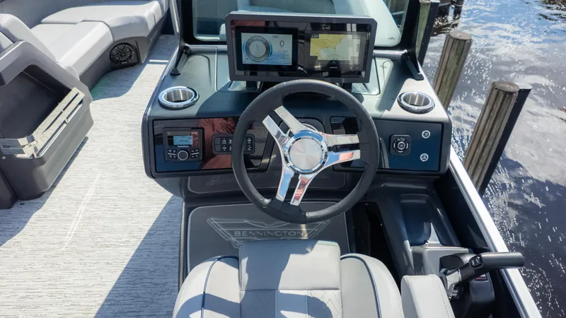Slide: The Image of 2025 Bennington 22 MFB boat dashboard with steering wheel and digital displays. - 22
