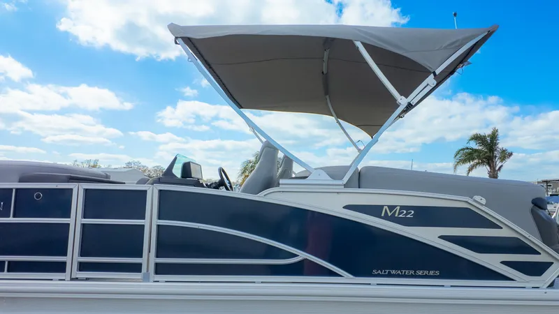 Slide: The Image of 2025 Bennington 22 MFB pontoon boat with canopy under blue sky. - 26