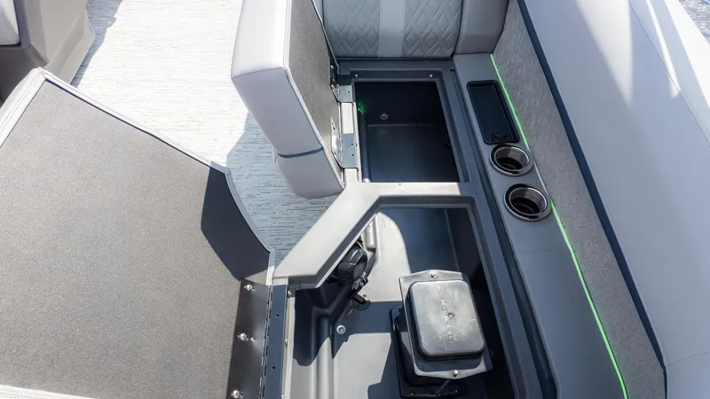 Slide: The Image of 2025 Bennington 22 MFB boat interior with open storage compartment and cup holders. - 9
