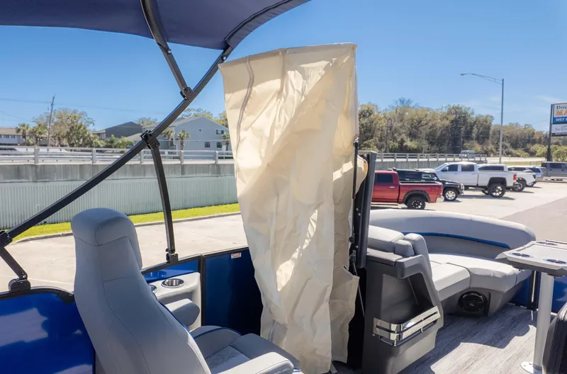 Slide: The Image of 2025 Bennington 22 MSB pontoon boat interior with seating and privacy curtain. - 13
