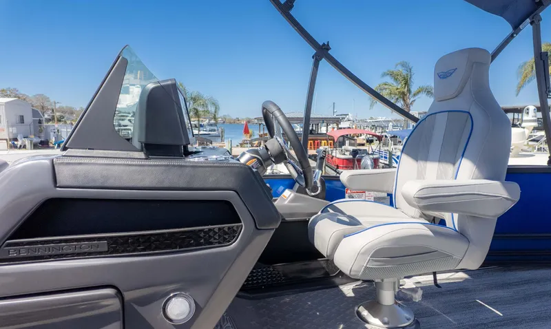 Slide: The Image of 2025 Bennington 22 MSB boat interior with captain's chair and steering console. - 18