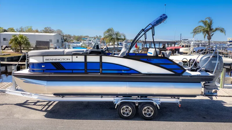 Slide: The Image of 2025 Bennington 22 MSB pontoon boat on trailer at marina. - 22