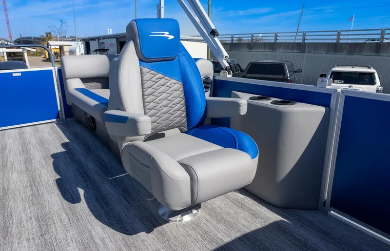 Slide: The Image of 2025 Bennington 22 SSR boat interior with blue and gray seating, cup holders, and modern design. - 13