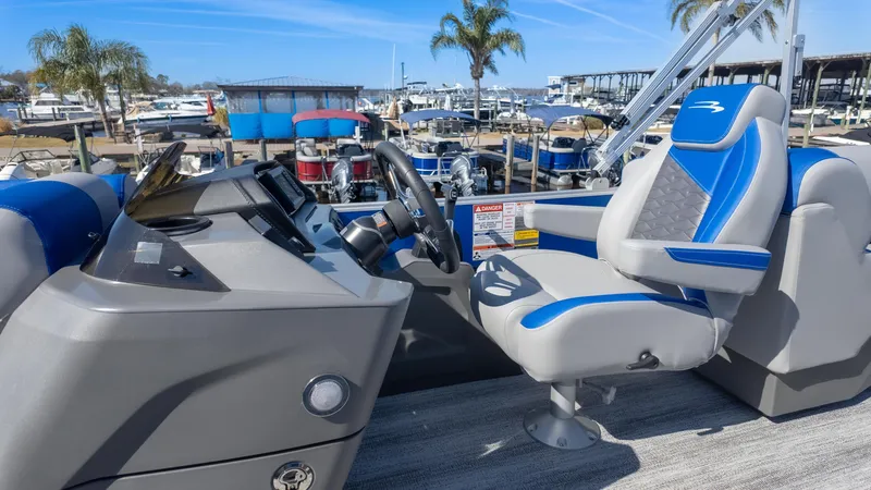 Slide: The Image of 2025 Bennington 22 SSR boat interior with modern helm and blue-accented captain's chair. - 18