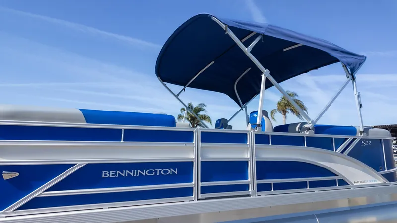Slide: The Image of 2025 Bennington 22 SSR pontoon boat with blue canopy and sleek design. - 21