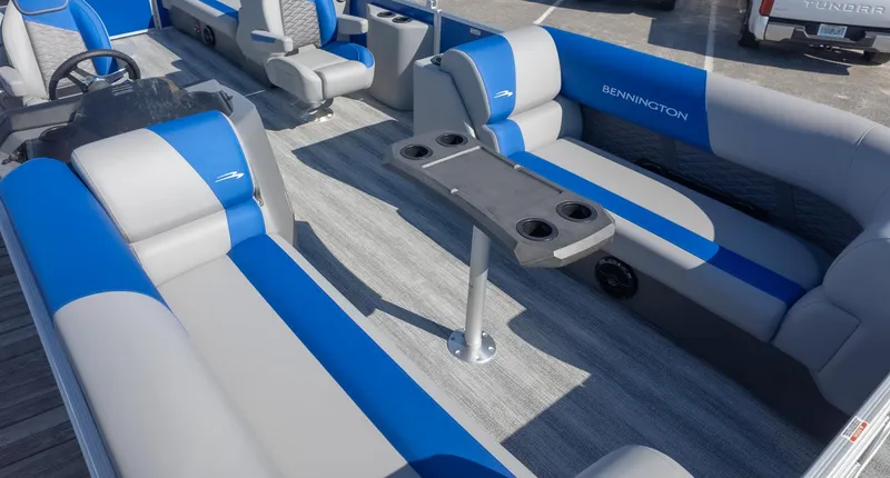 Slide: The Image of 2025 Bennington 22 SSR pontoon boat interior with blue and gray seating and cup holders. - 4