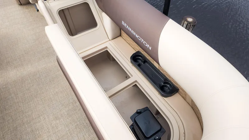 Slide: The Image of 2025 Bennington 22 SSR boat interior storage compartment with cup holders, beige upholstery. - 13