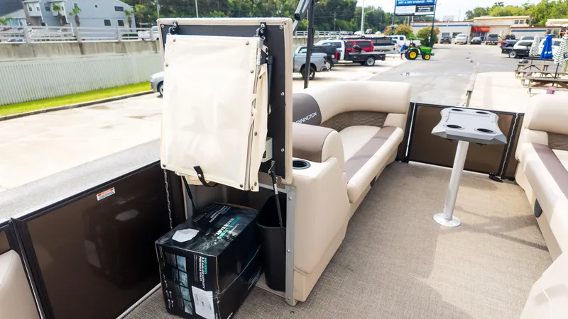 Slide: The Image of 2025 Bennington 22 SSR pontoon boat interior with seating and table, parked outdoors. - 17