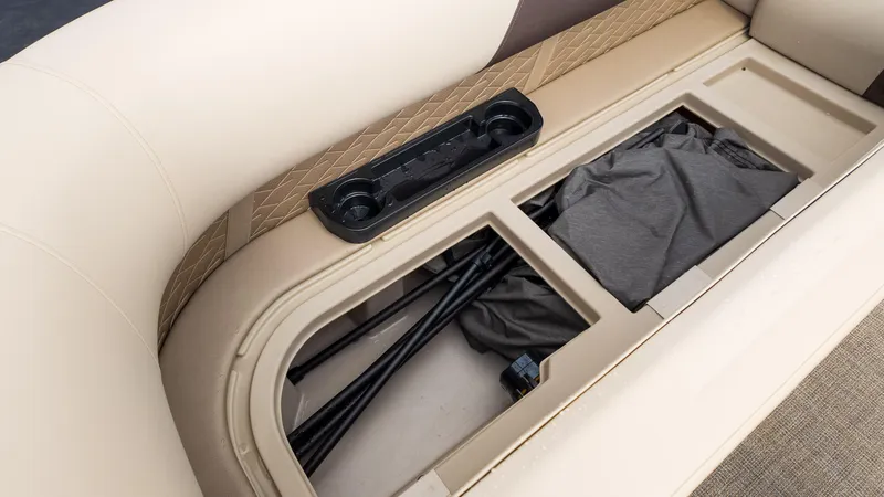Slide: The Image of 2025 Bennington 22 SSR boat storage compartment with beige seating and cup holders. - 20