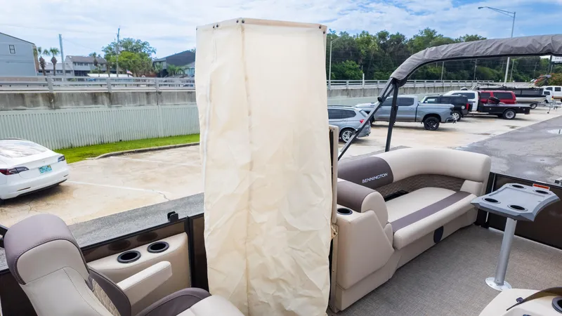 Slide: The Image of 2025 Bennington 22 SSR pontoon boat interior with seating and privacy curtain. - 27