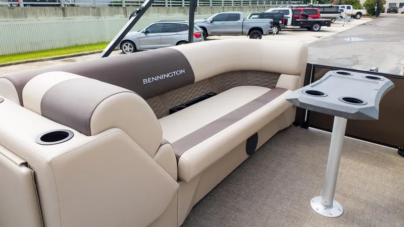 Slide: The Image of 2025 Bennington 22 SSR boat interior with beige seating and cupholder table. - 28