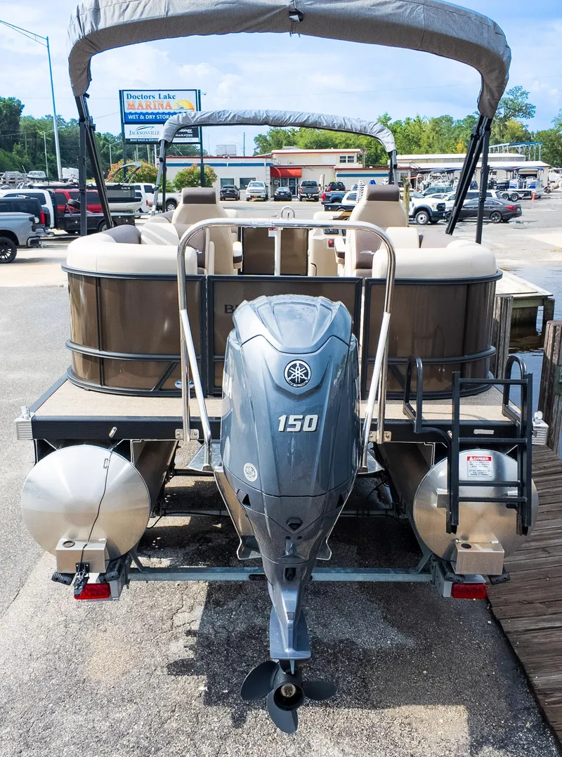 Slide: The Image of 2025 Bennington 22 SSR pontoon boat with Yamaha 150 outboard motor, parked at marina. - 4