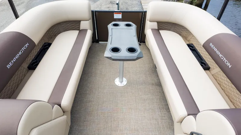 Slide: The Image of 2025 Bennington 22 SSR boat interior with beige seating and central table. - 9