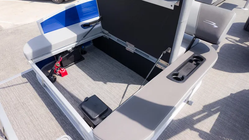 Slide: The Image of 2024 Bennington 22 SVSB boat storage compartment with open seat and cup holders. - 16