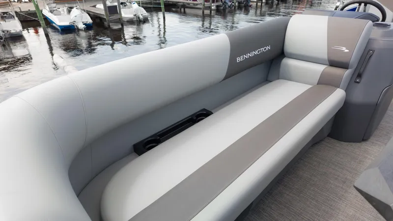 Slide: The Image of 2024 Bennington 22 SVSB boat interior with gray seating, docked by the water. - 24