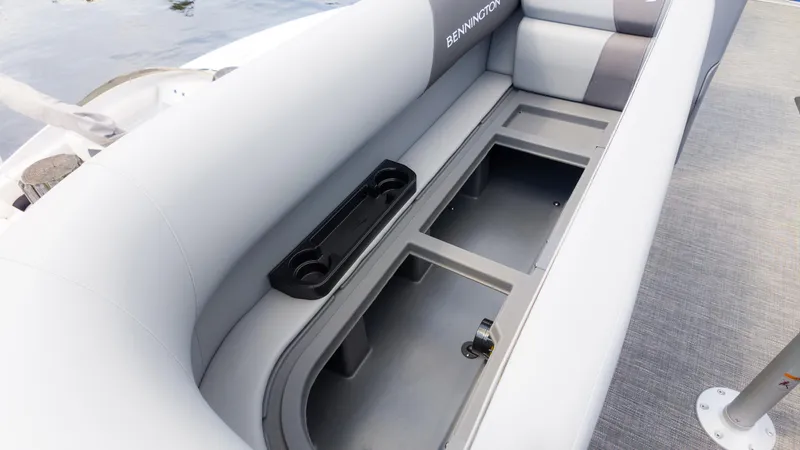 Slide: The Image of 2024 Bennington 22 SVSB boat interior with open storage compartment and cup holders. - 25