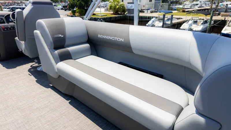 Slide: The Image of 2024 Bennington 22 SVSR boat interior with gray seating at a marina. - 11