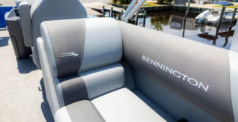 Slide: The Image of 2024 Bennington 22 SVSR boat interior with gray seating and logo by the water. - 12