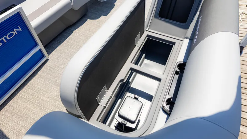 Slide: The Image of 2024 Bennington 22 SVSR boat seat storage compartment, open with visible interior space. - 13