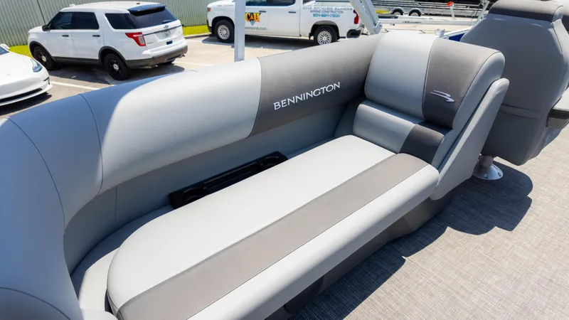 Slide: The Image of 2024 Bennington 22 SVSR boat interior with gray seating in a parking lot. - 15