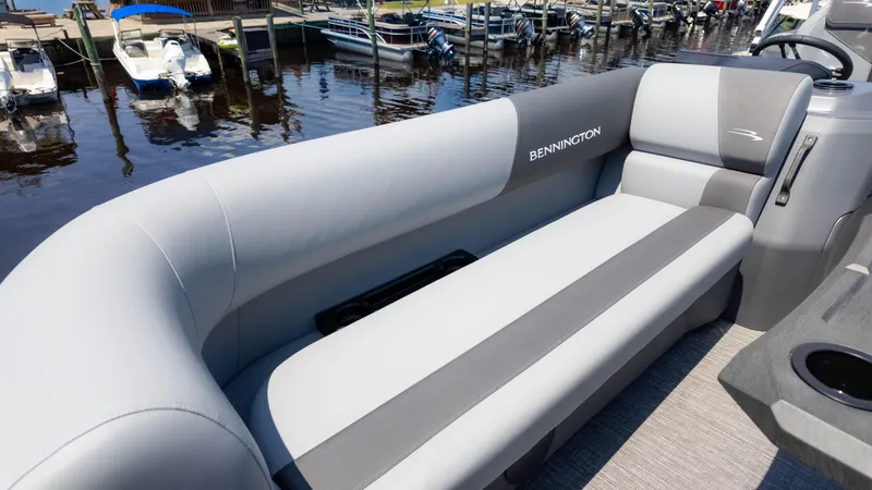 Slide: The Image of 2024 Bennington 22 SVSR pontoon boat with sleek gray seating at a marina. - 21