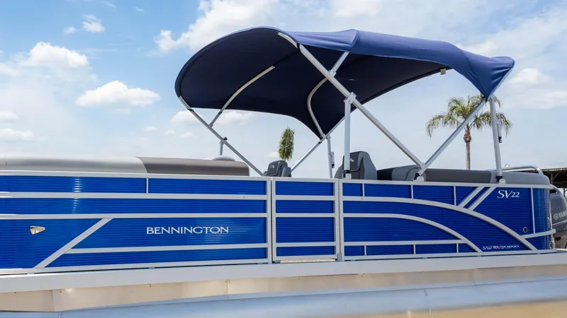 Slide: The Image of 2024 Bennington 22 SVSR pontoon boat with blue canopy and sleek design. - 25