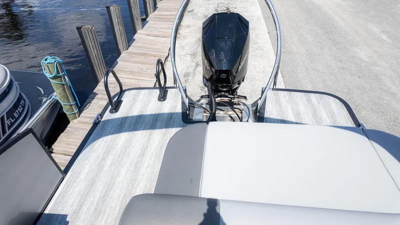 Slide: The Image of 2025 Bennington 23 SSB boat docked, featuring a sleek outboard motor and spacious deck. - 13