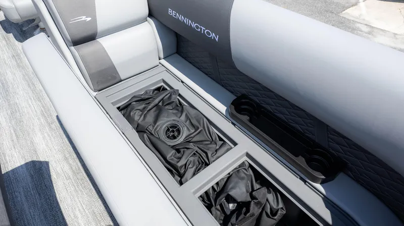 Slide: The Image of 2025 Bennington 23 SSB boat interior with storage compartment and cup holders. - 19