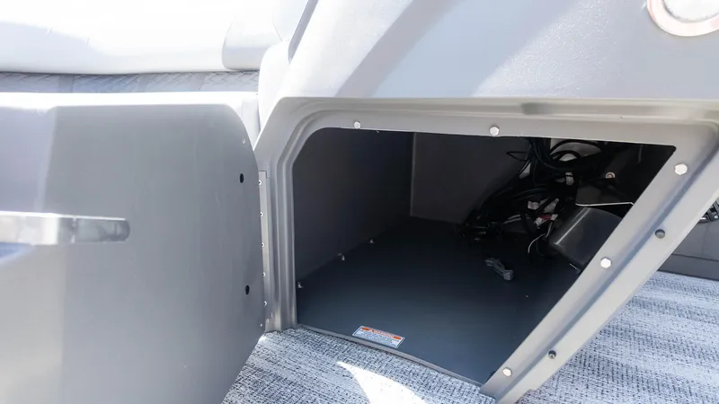 Slide: The Image of Open storage compartment in 2025 Bennington 23 SSB boat, showing interior space and wiring. - 21